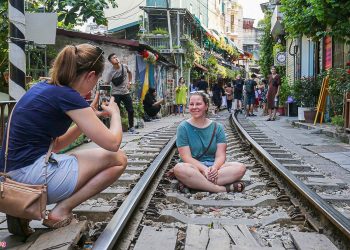 Tourists still take photos at the train station cafe street in Hanoi