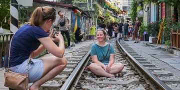 Tourists still take photos at the train station cafe street in Hanoi